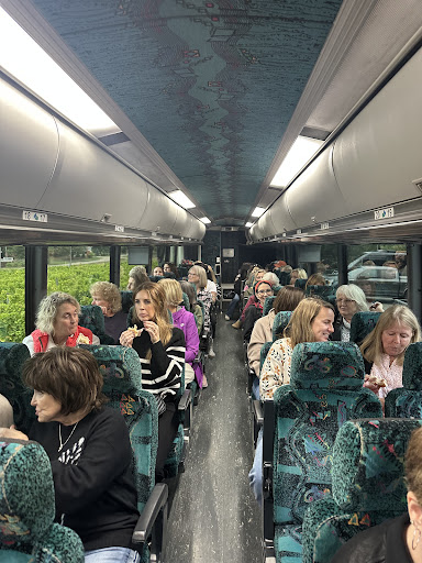 Interior view of a 56-passenger charter bus by Great Lakes Motor Coach, featuring comfortable seating, passengers enjoying the ride, and a spacious layout ideal for group travel.